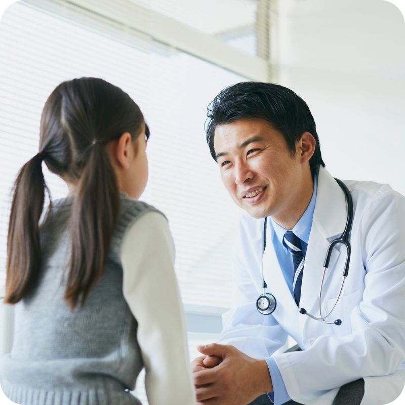 family with children at preventive eye consultation, ophthalmologist explaining eye care, relaxed atmosphere
